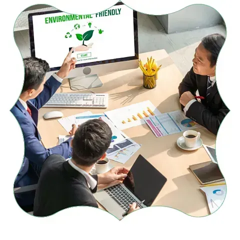 Durante una reunión, un equipo de oficina revisa un gráfico de tendencias ambientales en un monitor grande.